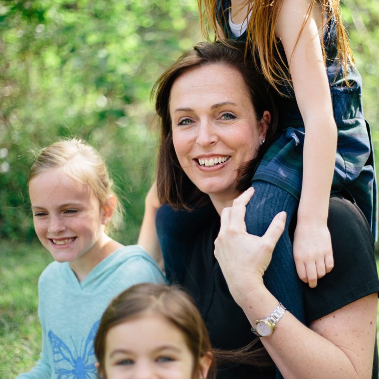 Bild: Mutter mit drei Kindern, alle sehen fröhlich aus